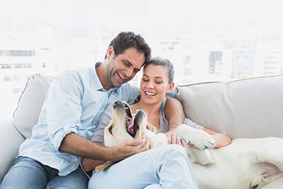 Couple with Dog Enjoying Air Conditioning in Their Home